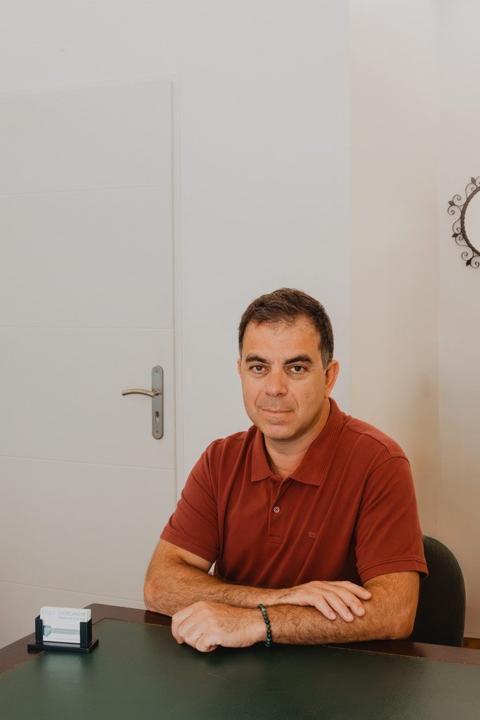 Portrait de Philippe Kaladjian, ostéopathe D.O., à son bureau du cabinet de Pertuis